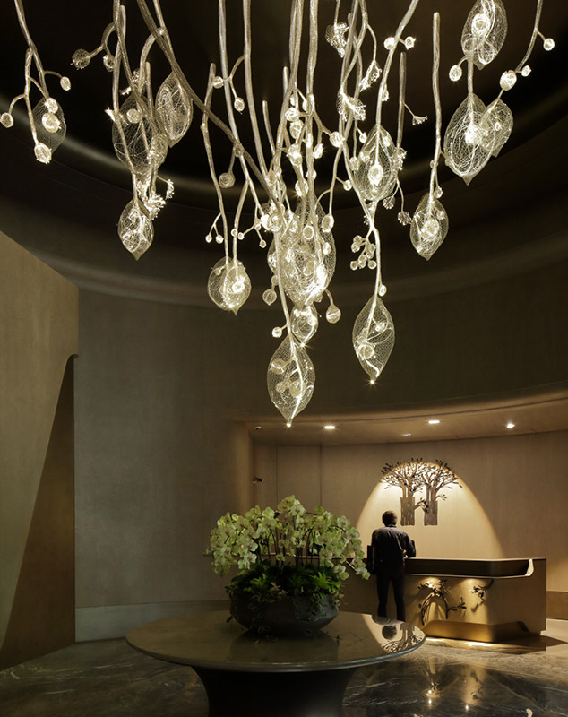 ‘Blossom Beneath the Sky’ is a handcrafted creation by artisan Huang Yu-chih, woven from copper wire. Light from fiber optics filters through the intertwining branches and buds, evoking the glow of twinkling starlight. - Humbleness Gendii